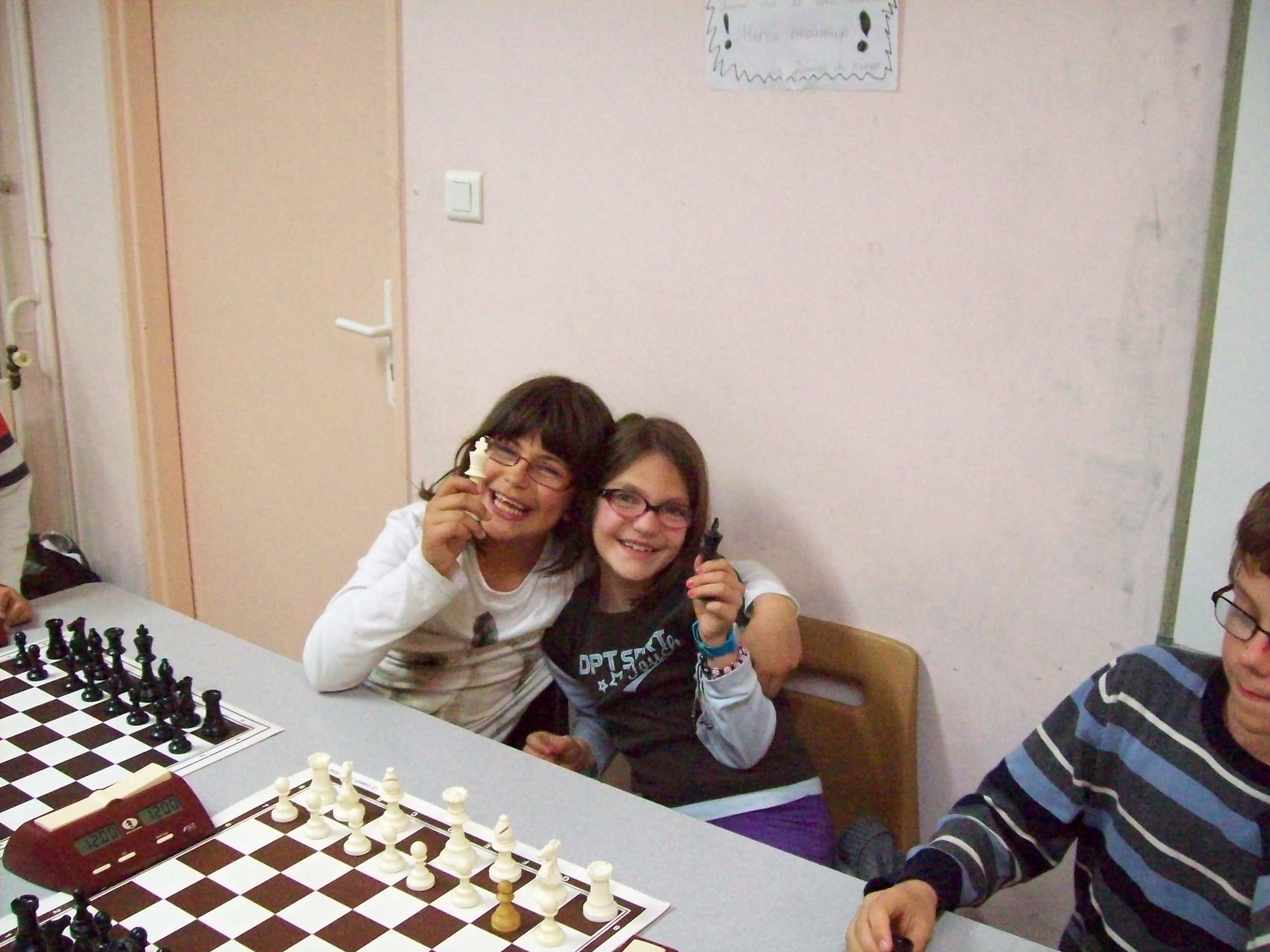 Deux enfants montrent des pièces de jeu d'échecs